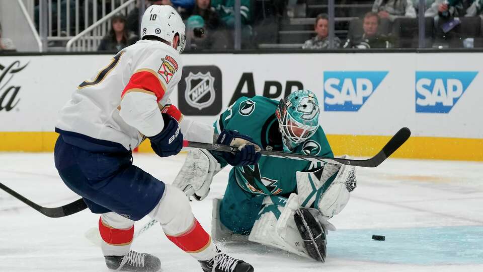 Florida Panthers left wing A.J. Greer, left, scores against San Jose Sharks goaltender Alexandar Georgiev during the second period of an NHL hockey game in San Jose, Calif., Saturday, Jan. 25, 2025.