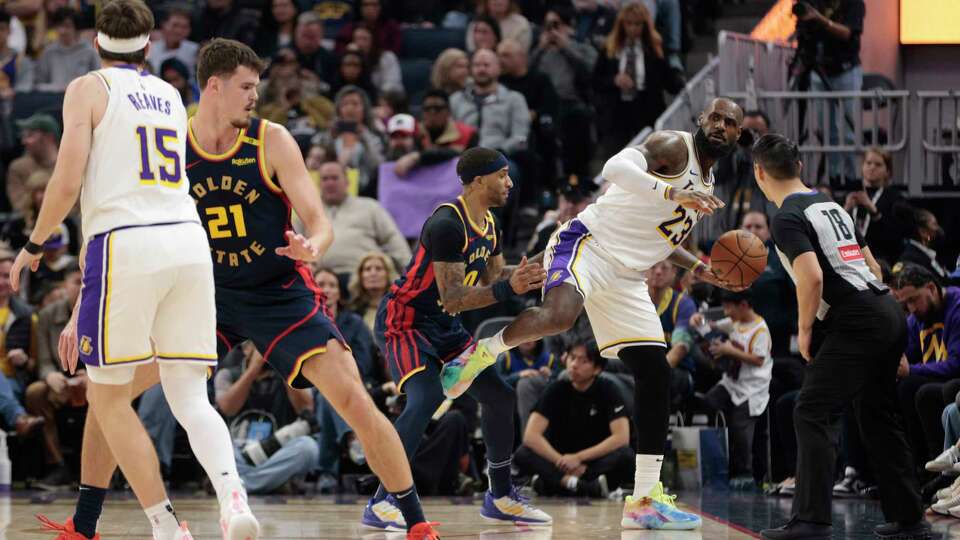 Los Angeles Lakers forward LeBron James (23) keeps the ball in play as he keeps his balance against Golden State Warriors guard Gary Payton II (0) in the second quarter during an NBA game at Chase Center in San Francisco, Saturday, Jan. 25, 2025.