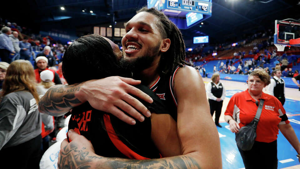 Houston guard Emanuel Sharp, front right, hugs his mother as they celebrate after a double overtime win in an NCAA college basketball game against Kansas, Saturday, Jan. 25, 2025, in Lawrence, Kan. (AP Photo/Colin E. Braley)