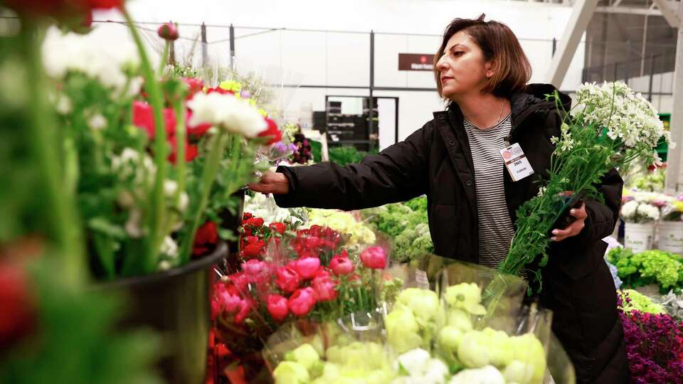 Priya Mistry looks through rows of flowers at Miguel Flowers inside the San Francisco Flower Market in San Francisco, California Wednesday, Jan. 15, 2025.