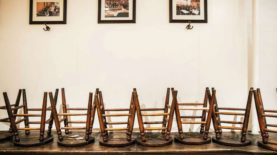 Stools are seen on a bench in a closed dining area inside Sam Wo Restaurant in San Francisco, California Wednesday, Jan. 26, 2022. The legacy restaurant, found in 1912, has been doing takeout only amid the ongoing COVID-19 pandemic.