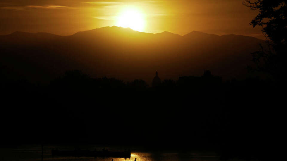 Sun sets by Mount Blue Sky, top, and Colorado State Capitol Building, front, at Denver, Colorado on Wednesday, October 20, 2021. The mountain was known as Mount Evans on the day the photo was taken.