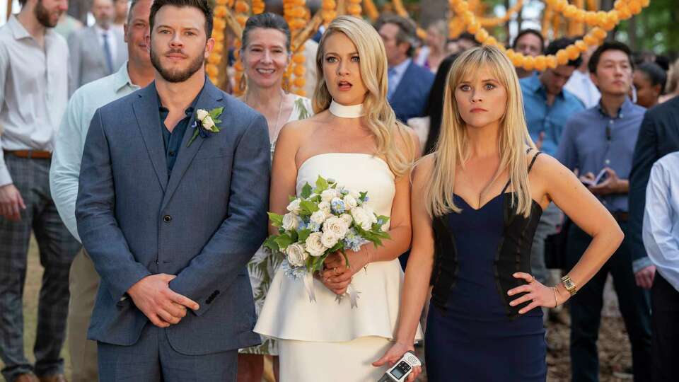 This image released by Amazon Prime Video shows Jimmy Tatro, from left, Meredith Hagner, and Reese Witherspoon in a scene from 'You're Cordially Invited.' (Glen Wilson/Amazon Prime Video via AP)