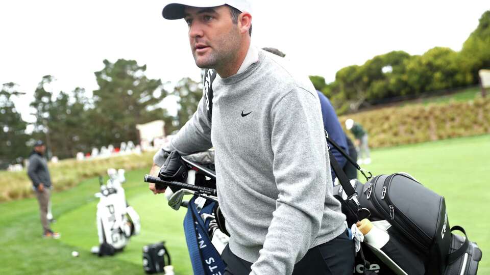 Scottie Scheffler carries his clubs during AT&T Pebble Beach Pro-Am practice round at Spyglass Hill in Pebble Beach, Calif., on Wednesday, January 29, 2025.