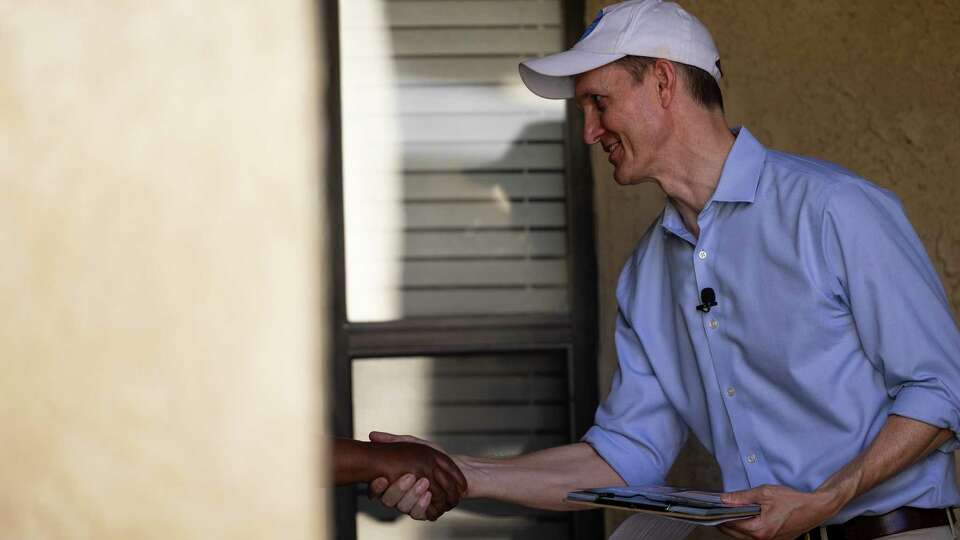 George Whitesides shakes hands with Tanya King, 64, at her front door in Lancaster, California, on July 27, 2024.