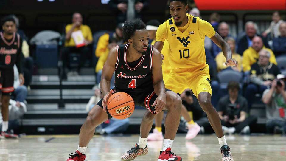 Houston guard L.J. Cryer (4) is defended by West Virginia guard Sencire Harris (10) during the first half of an NCAA college basketball game, Wednesday, Jan. 29, 2025, in Morgantown, W.Va. (AP Photo/Kathleen Batten)