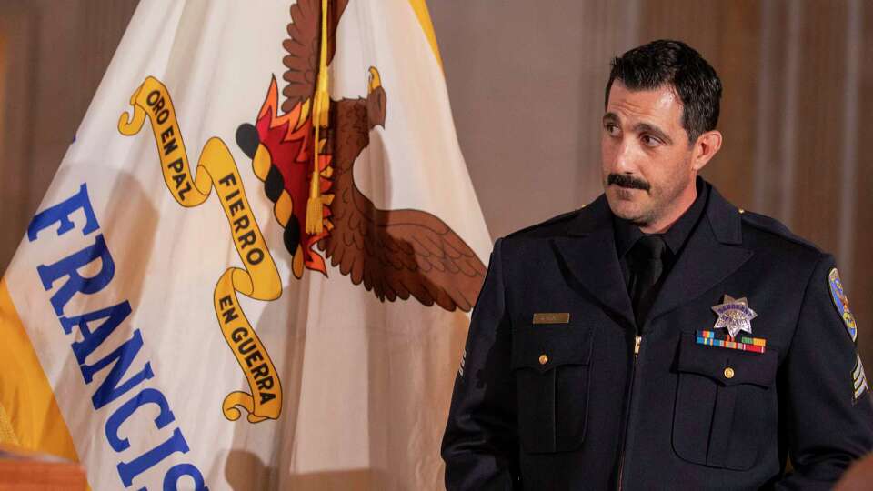 Sgt. Michael Horan stands by to be awarded at a ceremony on the second floor of City Hall in San Francisco on Wednesday, Jan. 29, 2025. Horan is being honored for being the officer who identified Luigi Mangione, possibly before anyone else in in the nation after the killing of UnitedHealthcare CEO Brian Thompson.