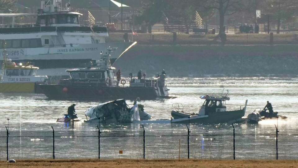 Search and rescue efforts are seen around a wreckage site in the Potomac River from Ronald Reagan Washington National Airport, early Thursday morning, Jan. 30, 2025, in Arlington, Va. (AP Photo/Mark Schiefelbein)