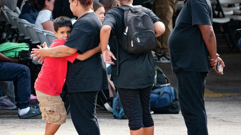 A child hugs his mother as they stand in line at the San Antonio Migrant Resource Center on San Pedro on Thursday, Sept. 21, 2023. A surge of migrants, mostly from Venezuela, has arrived at the Texas/Mexico border in recent days.