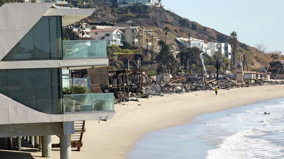 A mixture of burned and untouched homes during aftermath of Palisades Fire along Pacific Coast Highway in Malibu, California on Sunday, January 12, 2025.