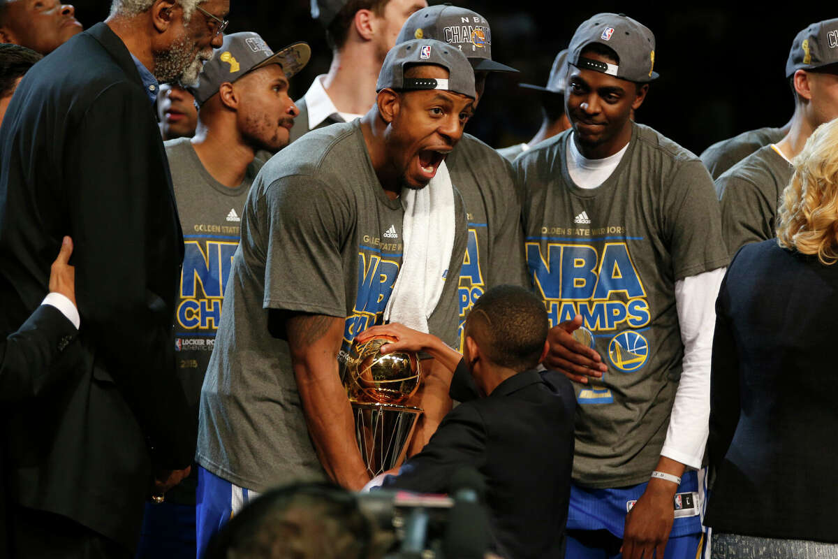 Golden State Warriors' Andre Iguodala celebrates after receiving the MVP trophy from NBA legend Bill Russell after the Golden State Warriors 105-97 win over the Cleveland Cavaliers in Game 6 of the NBA Finals to win the NBA Championship at Quicken Loans Arena in Cleveland, Ohio, on Tuesday, June 16, 2015.