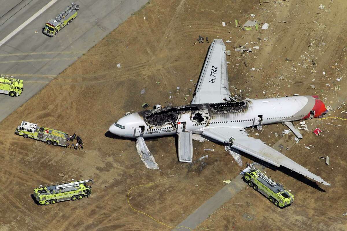 The destroyed fuselage of Asiana Airlines Flight 214 is visible on the runway at San Francisco International Airport after it crashed on landing and burned on Saturday, July 6, 2013.