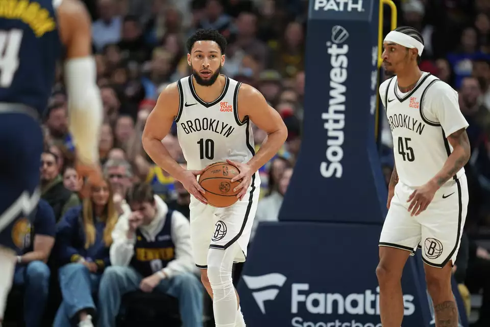 Brooklyn Nets guards Ben Simmons (10) and Keon Johnson (45) in the first half of an NBA basketball game Friday, Jan. 10, 2025, in Denver. (AP Photo/David Zalubowski)