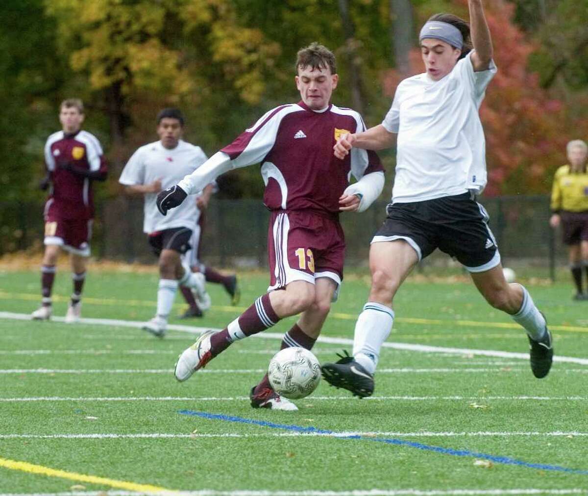 South Windsor High School's # 13, Evan Cheman, left, fights with Greenwich High School's #18, Phillip Collins in the first round of the Class LL boys soccer tournament hosted by Greenwich, on Monday, Nov. 8, 2010.