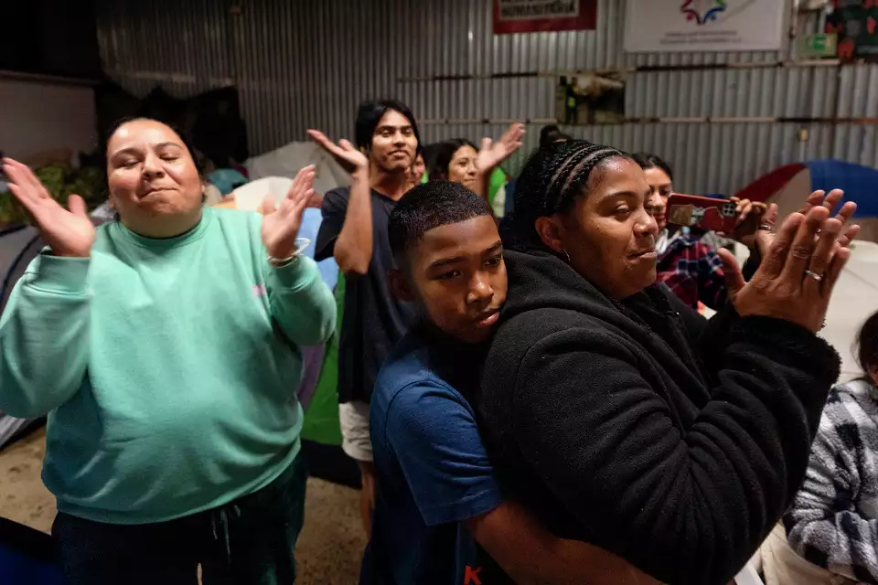 Margelis Rodriguez, a la derecha, de Venezuela, recibe un abrazo de su hijo Mickel durante una fiesta de cumpleaños en un refugio para migrantes en Tijuana, México, el miércoles 5 de febrero de 2025. (AP Foto/Gregory Bull)