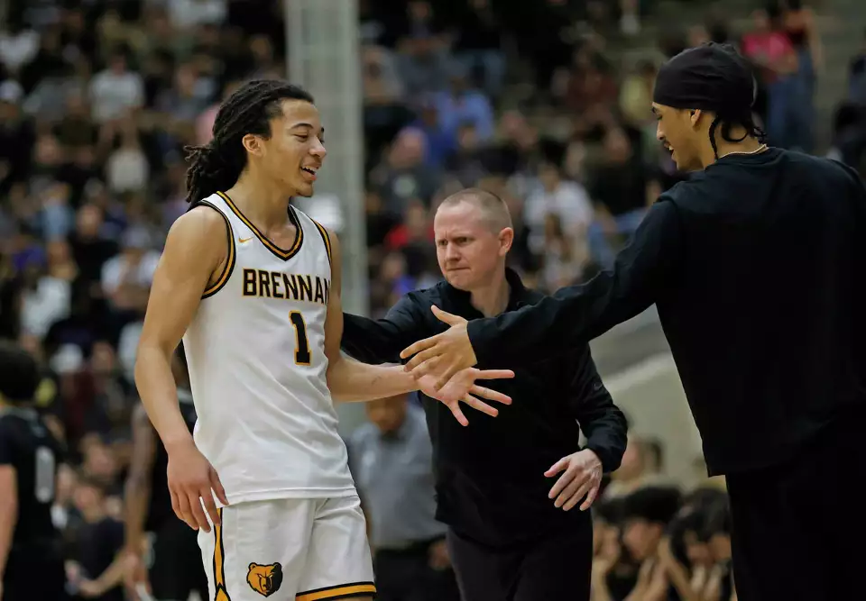 Brennan Bears Kingston Flemings (1) is congratulated by Brennan Bears head coach Koty Cowgill and Brennan Bears Isaiah Ward (42) who did not play due to an injury from second half of regional final matchup where Brennan defeated Steele 68-39 at Alamo Convocation Center on Friday, Feb.28, 2025