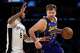 Los Angeles Lakers guard Luka Doncic (77) drives to the basket as San Antonio Spurs guard Stephon Castle (5) defends during the second half of an NBA basketball game in Los Angeles, Monday, March 17, 2025. (AP Photo/Kyusung Gong)