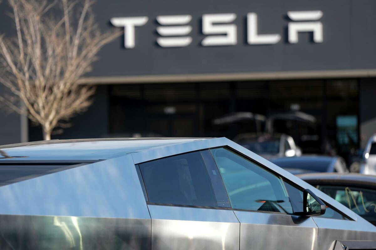 A Tesla Cybertruck and other Telsla vehicles sit at a dealership, Wednesday, March 19, 2025, in Kennesaw, Ga. (AP Photo/Mike Stewart)