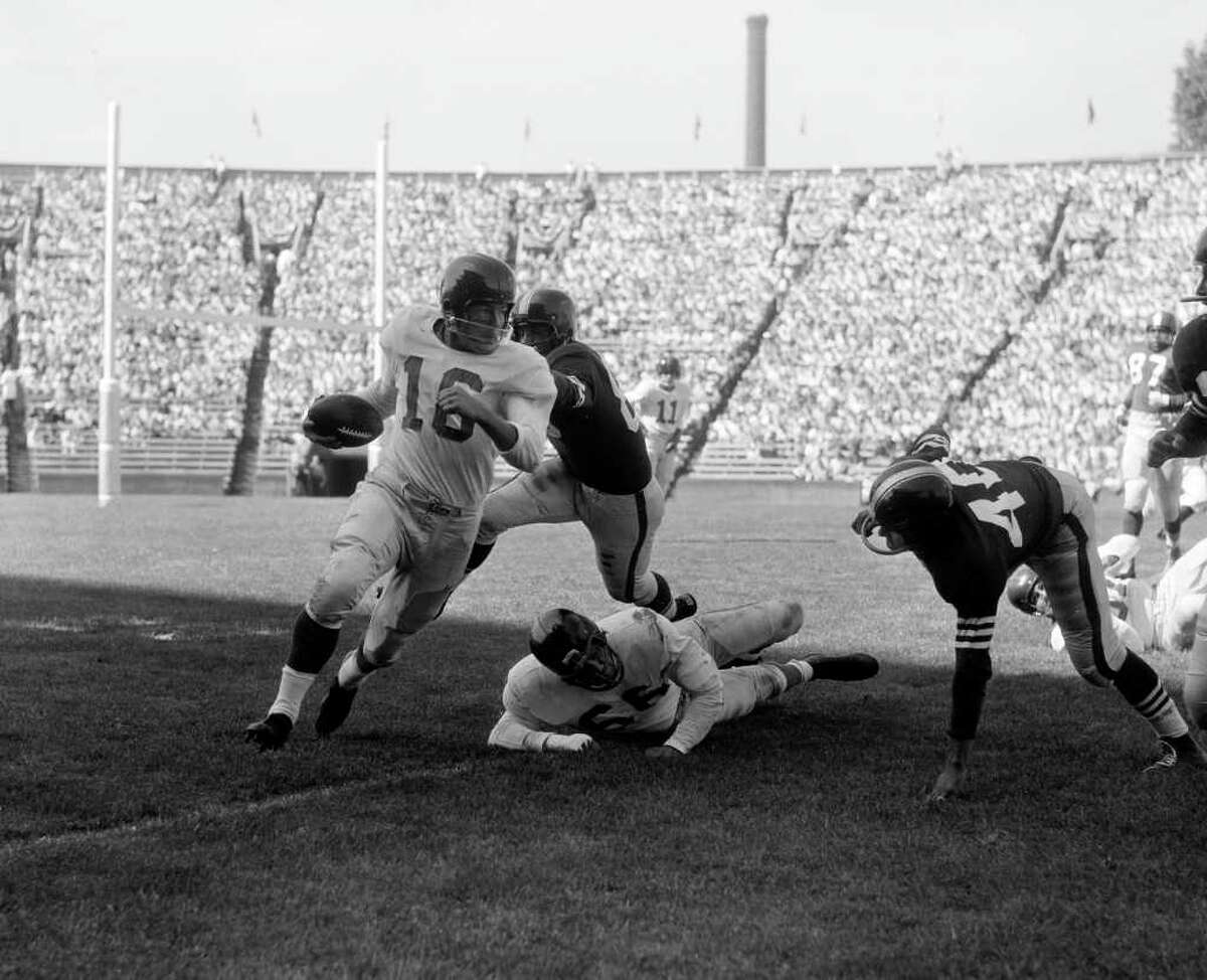 New York Giants' half back Frank Gifford carries the ball during pro exhibition game with the San Francisco 49ers, Aug. 20, 1955. Others are New York's Jack Stroud (66), on ground, and 49er George Maderos (40). (AP Photo)