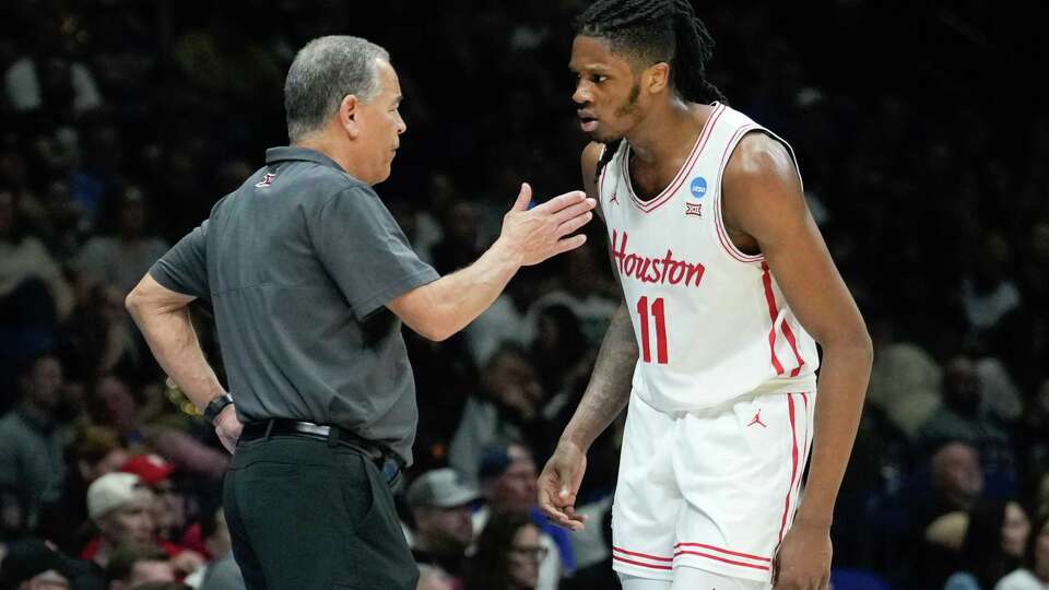 Houston head coach Kelvin Sampson, left, talks with forward Joseph Tugler after picking up his third foul during the second half of a Midwest Regional semifinal basketball game in the NCAA Tournament at Lucas Oil Stadium in Indianapolis, Friday, March 28, 2025.