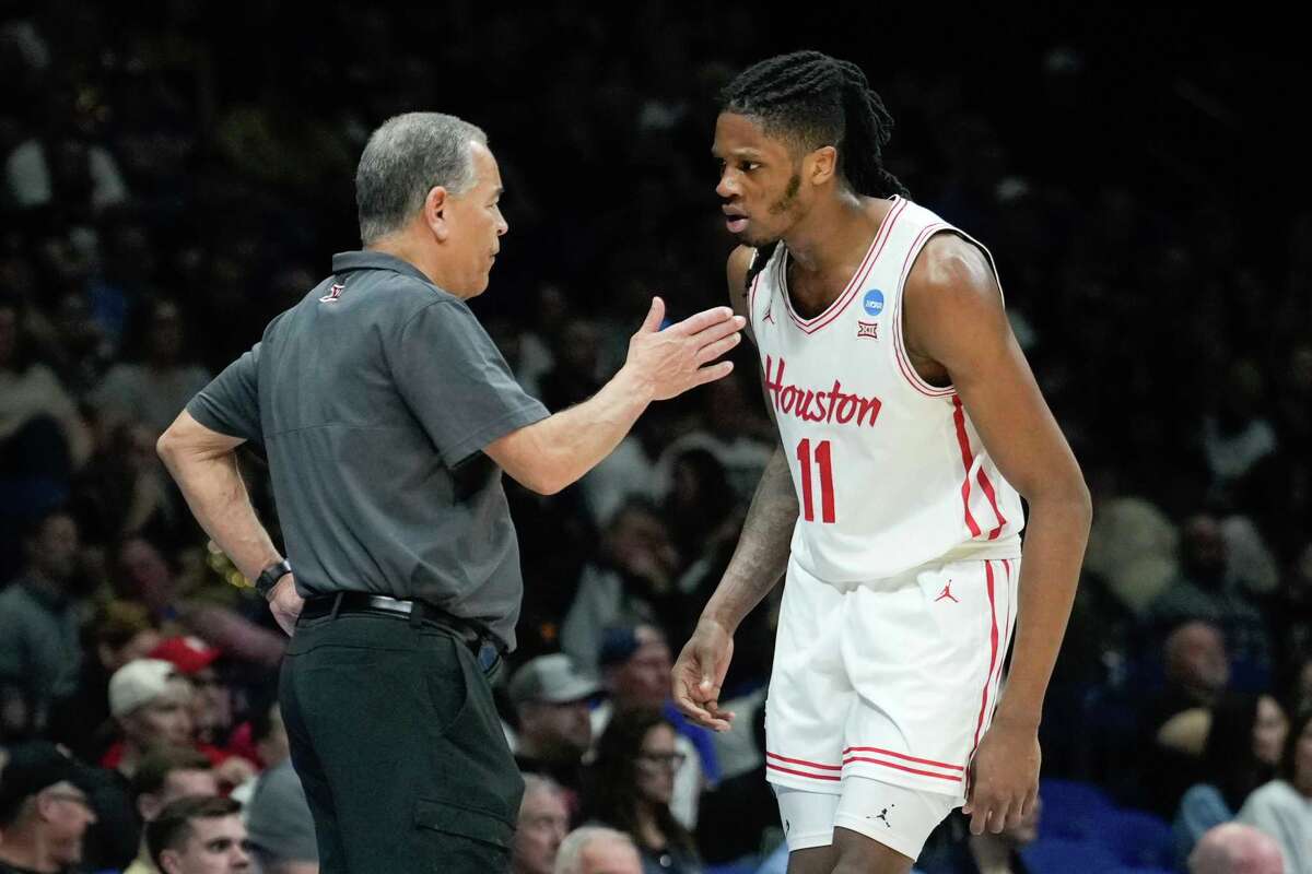 Houston head coach Kelvin Sampson, left, talks with forward Joseph Tugler after picking up his third foul during the second half of a Midwest Regional semifinal basketball game in the NCAA Tournament at Lucas Oil Stadium in Indianapolis, Friday, March 28, 2025.
