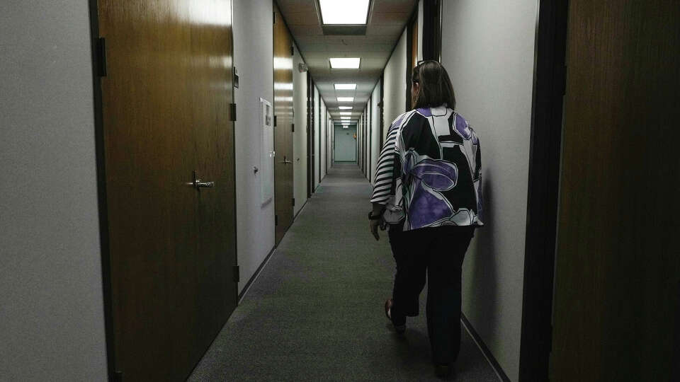 Kimberly Haynes, Southwest Regional Director of Church World Services, walks down an empty hallway lined with empty offices due to layoffs on Wednesday, March 5, 2025 in Houston.