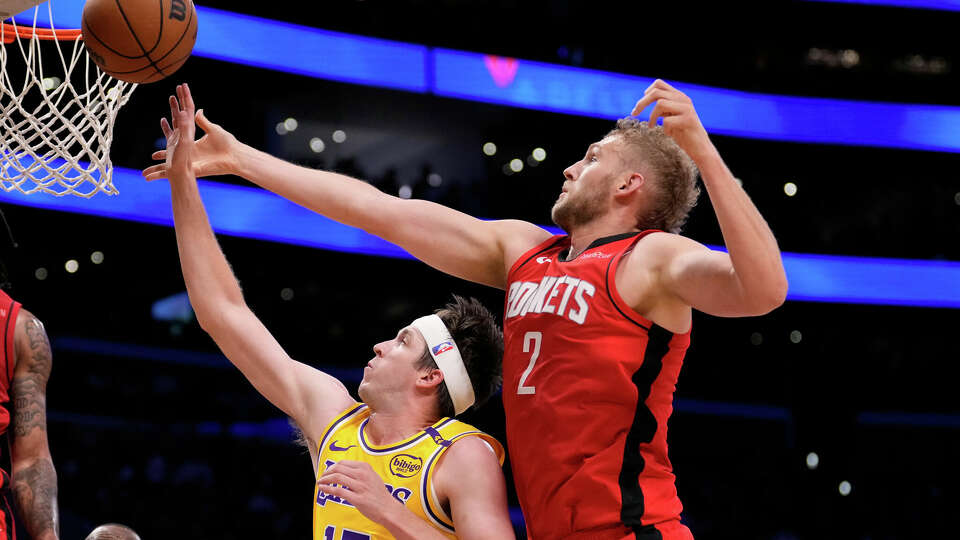 Los Angeles Lakers guard Austin Reaves, left, and Houston Rockets center Jock Landale reach for a rebound during the first half of an NBA basketball game Friday, April 11, 2025, in Los Angeles. (AP Photo/Mark J. Terrill)