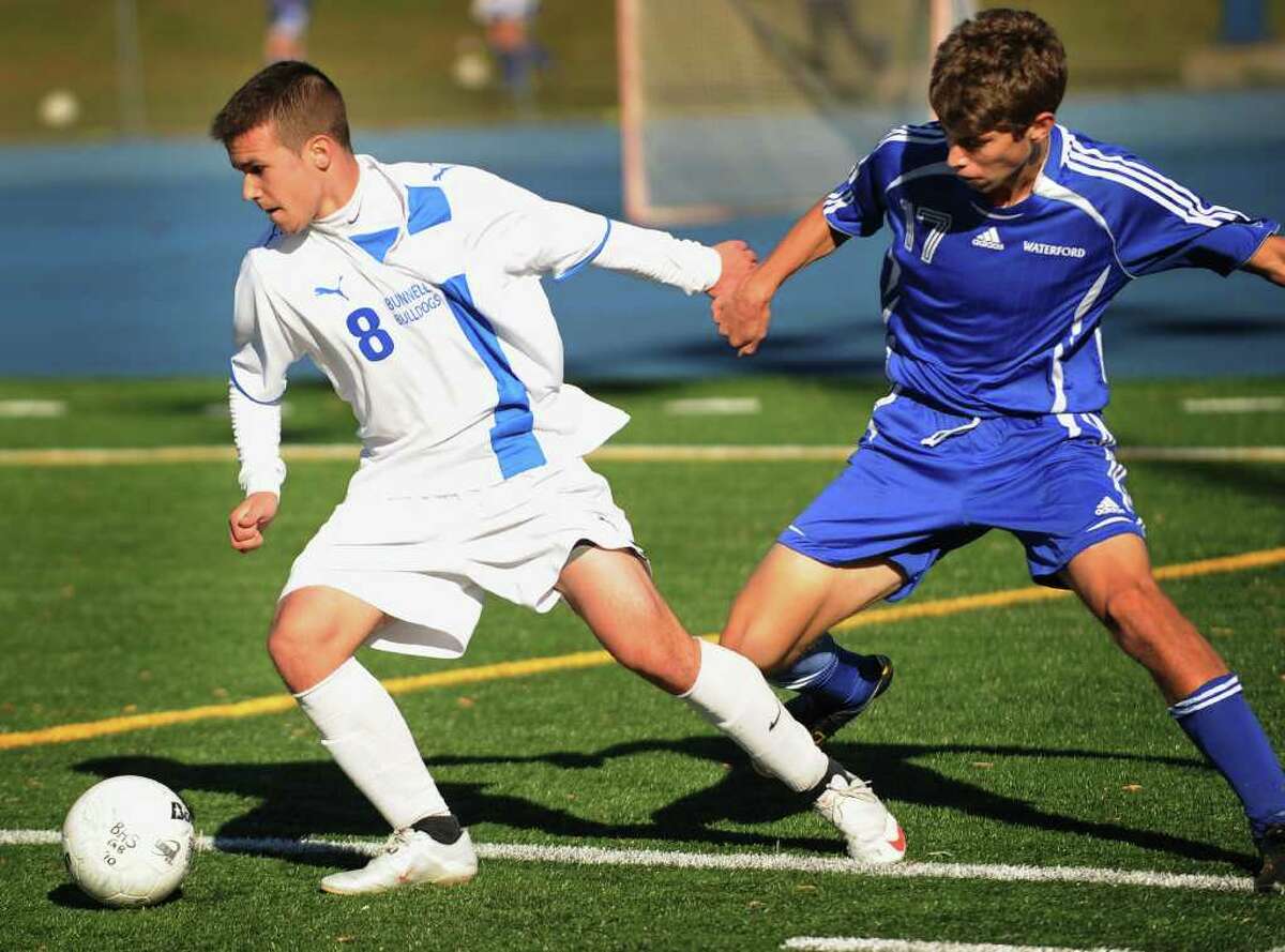 Bunnell's James Gillespie, left, plays the ball ahead of Waterford defender Evan Pias during the Bulldogs' 2-0 win in the second round of the Class L State Tournament at Bunnell High School in Stratford on Thursday, November 11, 2010.