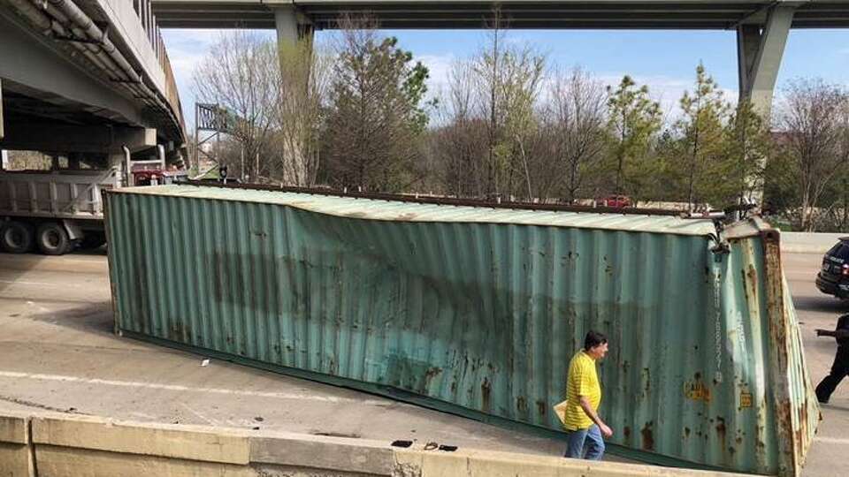 A container sits in the eastbound lanes of Interstate 10 after it struck the Houston Avenue bridge on Friday, March 2, 2018, in Houston. The truck hauling it was using a flatbed trailer, which made the container have a total height of more than 14 feet, officials said.
