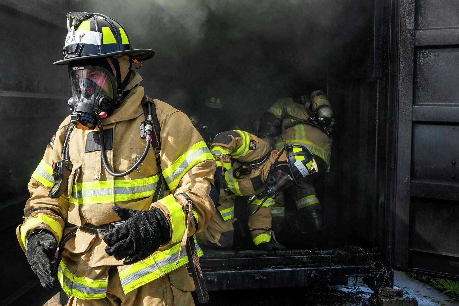 Cadet Travis Ray emerges from a smoke-filled structure as they participate in live fire training drill at the Houston Fire Department Val Jahnke Training Facility in Houston, Thursday, May 29, 2025.