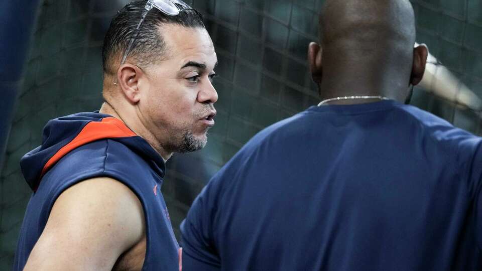 Houston Astros pitching coach Alex Cintrón, left, talks with Jordan Alvarez during batting practice before an MLB baseball game in Houston, Thursday, May 29, 2025.