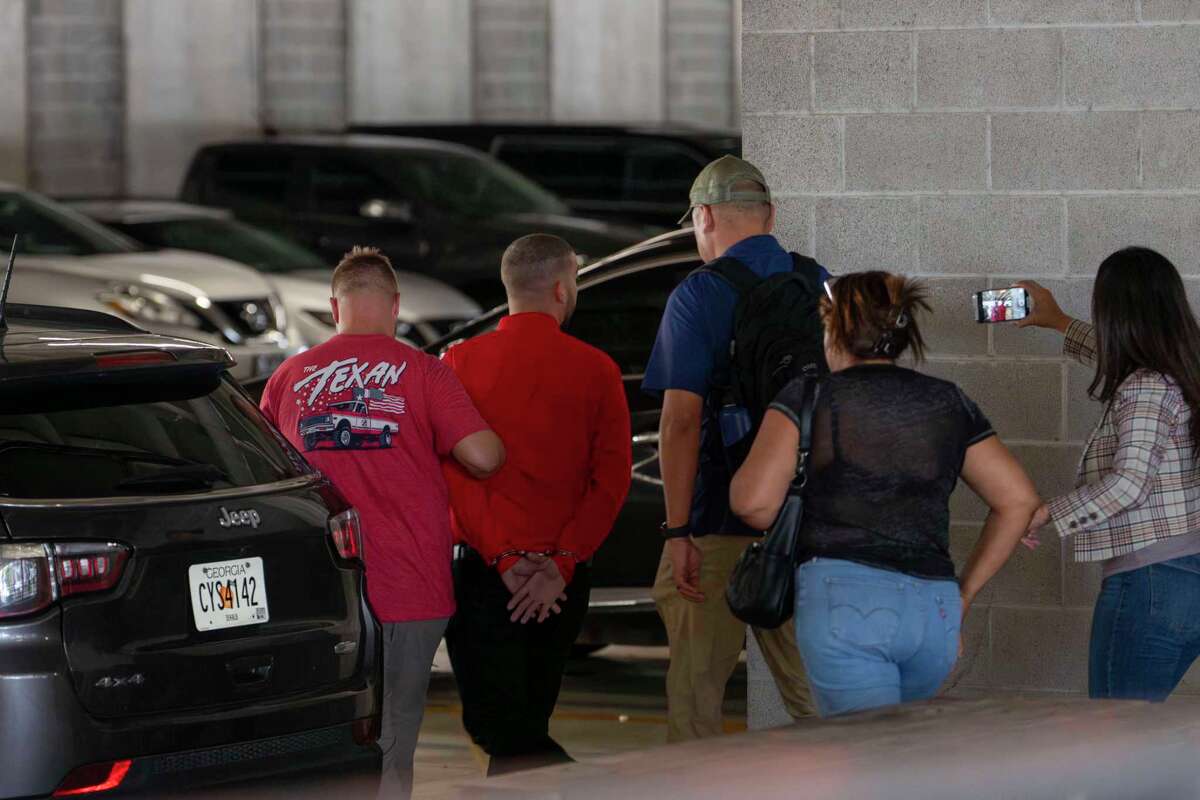 ICE agents lead a man in handcuffs from the entrance of the Federal Building where the immigration court resides on the tenth floor in Houston, Monday, June 9, 2025.