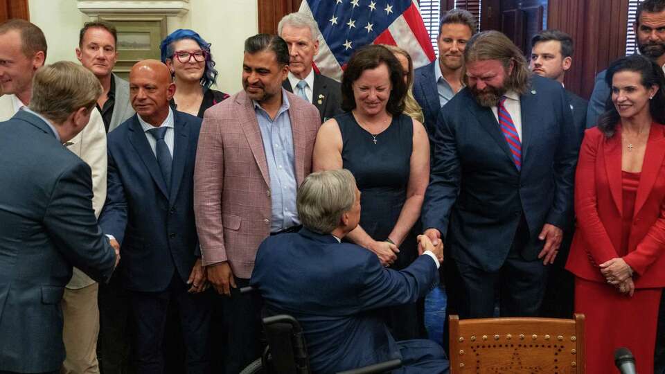 Gov. Greg Abbott greets supporters as he signs legislation that will provide a $50 million state investment to initiate clinical trials for ibogaine, a natural psychedelic extract from an African plant that advocates say can be a safe and effective alternative to opioids for the treatment of PTSD and opioid use disorder, at the Texas Capitol Wednesday, June 11, 2025.