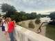 People observing the Comal River after severe storms on June 12, 2025.