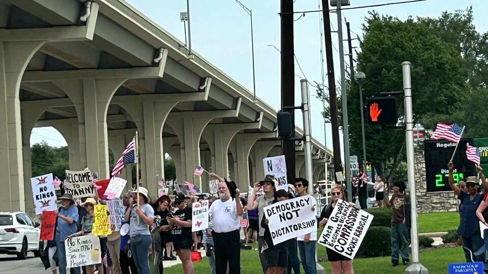 No Kings protesters hold up signs in Cypress on June 14, 2025.