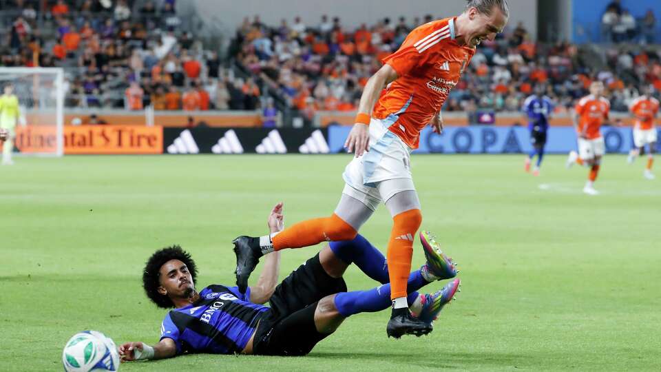 CF Montreal defender Jalen Neal, left, slide-tackles the ball away from Houston Dynamo midfielder Griffin Dorsey, right, during the second half of an MLS soccer match Saturday, June 14, 2025, in Houston.