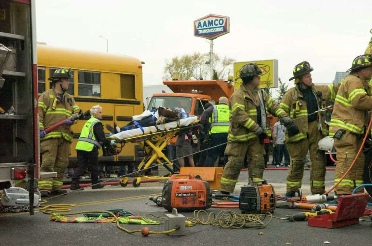 A woman is wheeled through the accident scene to an ambulance as Stamford Fire and Rescue work to extricate the driver of a box truck after a multi-vehicle accident shutting down a quarter-mile stretch of Route 1 on Stamford's East Side in Stamford, Conn., November 16, 2010. The accident occurred shortly before 2:30 p.m. when police reported a man driving erratically hit eight to nine cars, including a school bus carrying Stamford High School students.