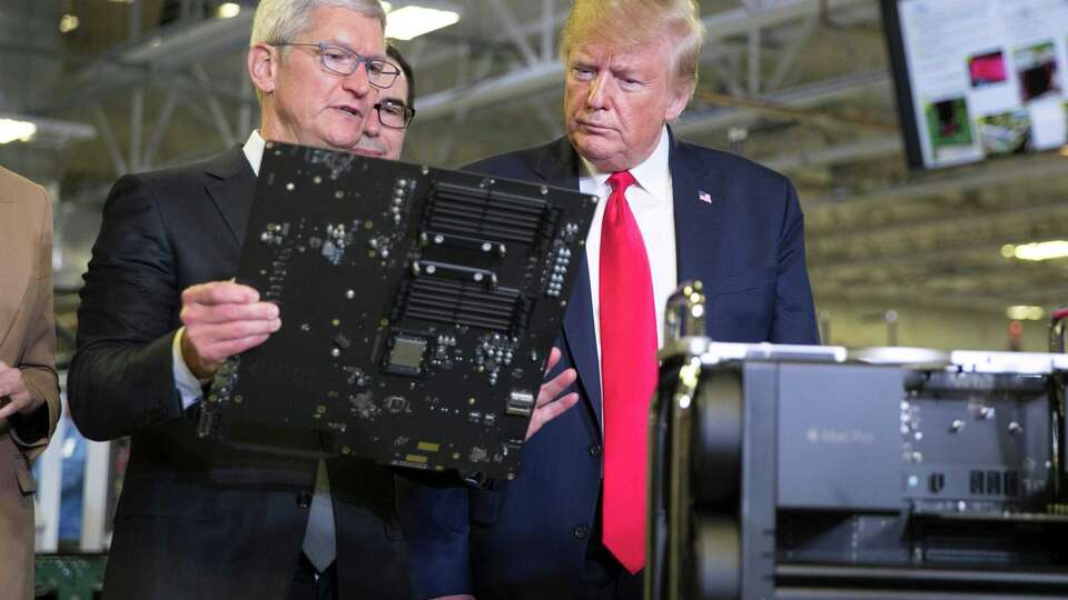 Then-President Donald Trump and Apple Inc. CEO Tim Cook tour an Austin manufacturing facility on Nov. 20, 2019. Trump will return to Austin on Saturday for his first event here since then.