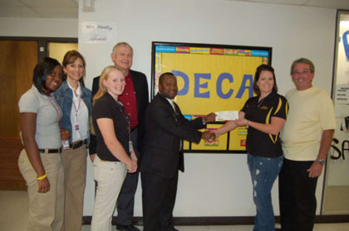 Bob & Nicole Sealy present a $2,000 check to Principal Victor Williams for the DECA program, accompanied by Career Tech Director Dr. Dean Miller, DECA Director Martha Morian and DECA members