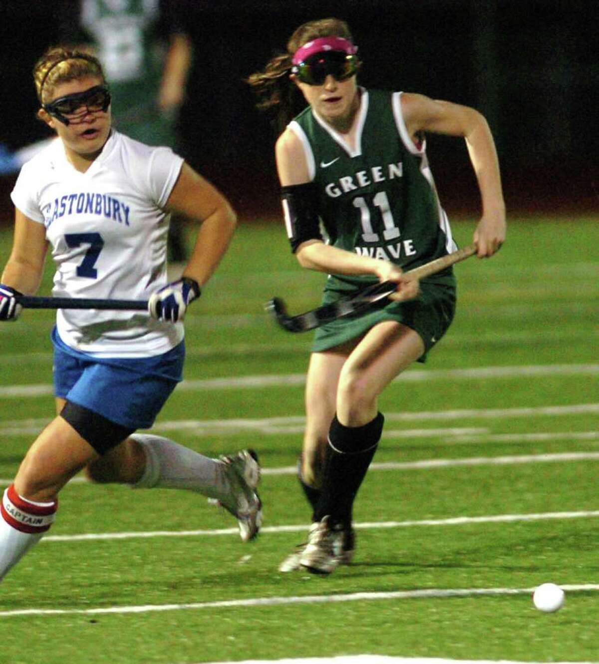New Milford's 11, Olivia Monteiro competes with Glastonbury's 7, Taylor Moreau during the field hockey game at Watertown High School Nov. 16, 2010.