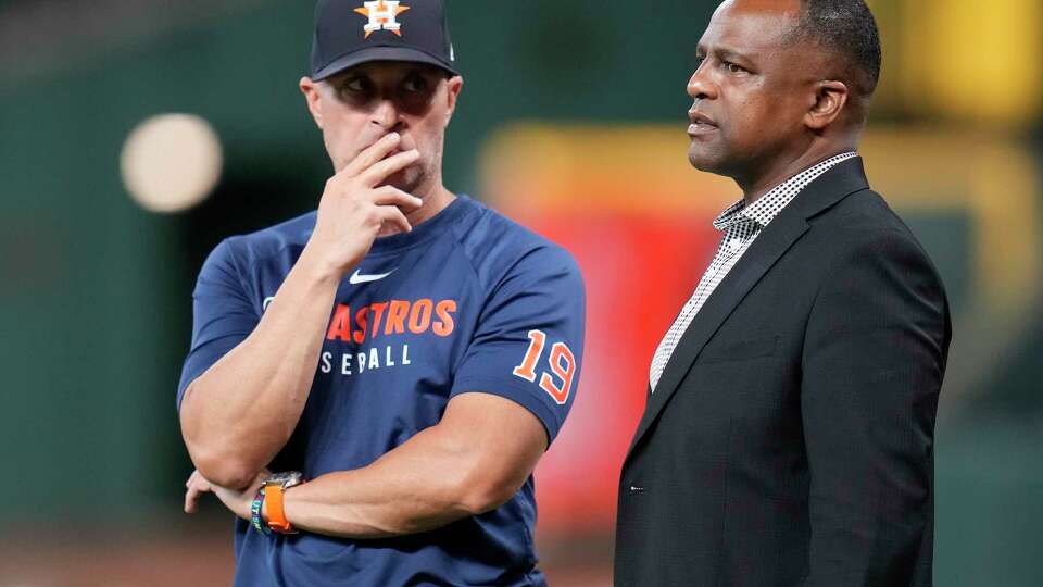 Houston Astros manager Joe Espada (19) speaks with general manager Dana Brown, right, during batting practice before a baseball game against the Philadelphia Phillies, Wednesday, June 25, 2025, in Houston. (AP Photo/Karen Warren)