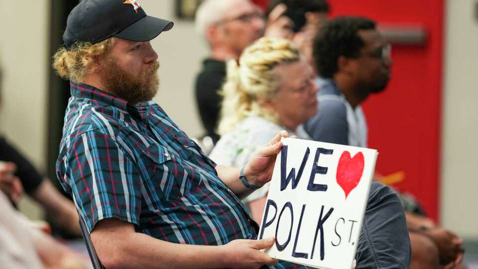 Kyle Rogers holds a sign as the Houston First Corporation holds a town hall with the public to discuss the results of the organization’s traffic study regarding a two-block section of Polk Street planned as part of a $2 billion expansion of the George R. Brown Convention Center in Houston, Tuesday, July 1, 2025. Community advocates are hoping to keep that section of Polk Street open as a major thorofare connecting East Downtown after Houston First, the entity that manages the convention center, was allowed by Houston City Council to acquire two plots of land for the expansion.