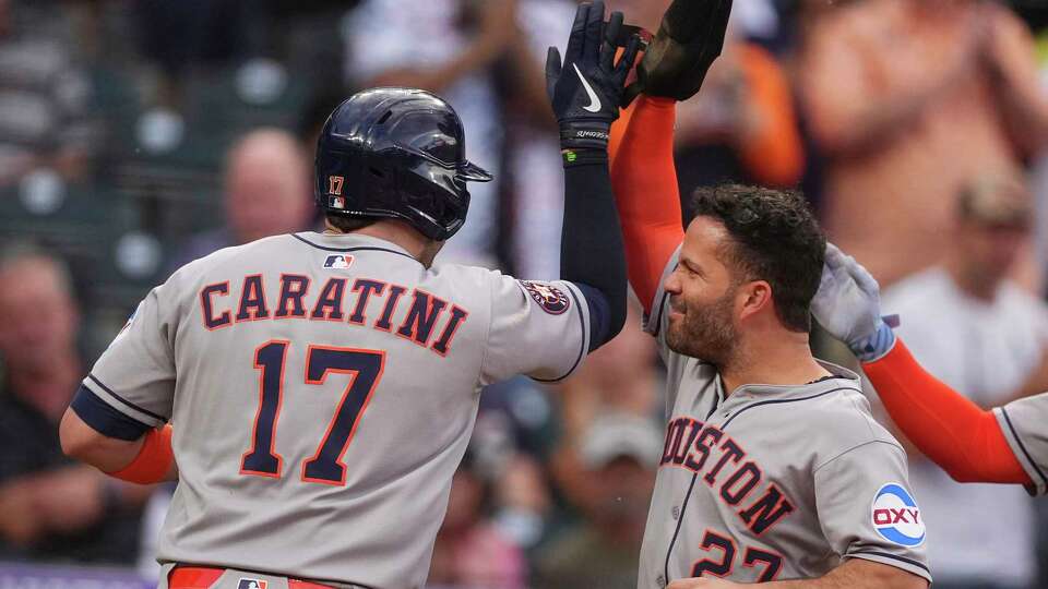 Houston Astros' Jose Altuve, right, congratulates Victor Caratini after his grand slam off Colorado Rockies starting pitcher Chase Dollander in the third inning of a baseball game Tuesday, July 1, 2025, in Denver. (AP Photo/David Zalubowski)