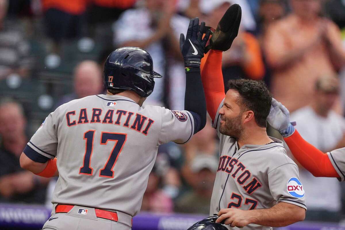 Houston Astros' Jose Altuve, right, congratulates Victor Caratini after his grand slam off Colorado Rockies starting pitcher Chase Dollander in the third inning of a baseball game Tuesday, July 1, 2025, in Denver. (AP Photo/David Zalubowski)