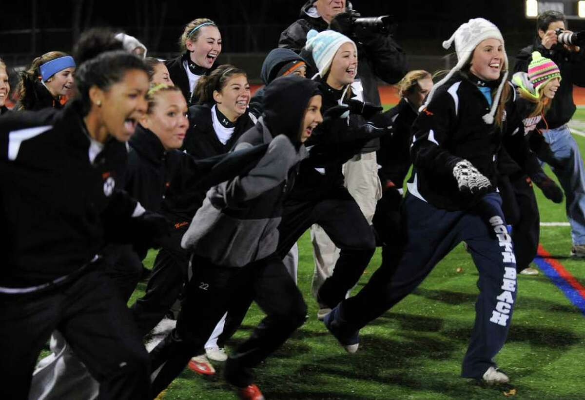 Shelton team members fly off the bench to celebrate their win over Westhill in Class LL girls final championship soccer in Norwalk, Conn. on Friday November 19, 2010.