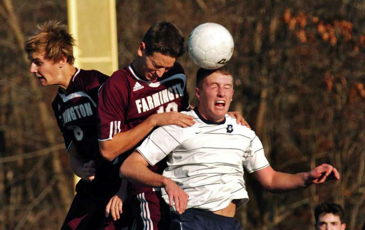 Staples #9 Brendan Lesch, right, tires to head the ball into the net from a sideline kick, during the 2010 Boys Soccer State Tournament Class LL final in Waterbury, Conn. on Saturday November 20, 2010. At left is Farmington's #8 Colin Troxell and his teammate #10 Michael DiTomasso. Staples was defeated 2-1.