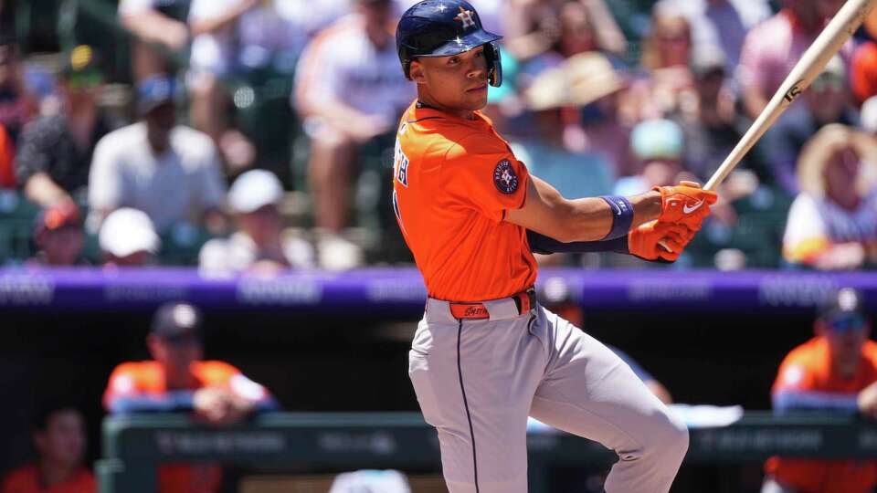 Houston Astros' Cam Smith doubles to drive in a run against Colorado Rockies starting pitcher Kyle Freeland in the first inning of a baseball game Thursday, July 3, 2025, in Denver. (AP Photo/David Zalubowski)