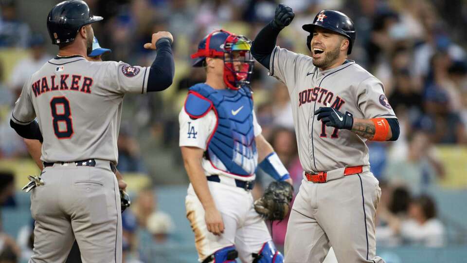 Houston Astros' Victor Caratini, right, celebrates after his grand slam with Christian Walker (8) during the sixth inning of a baseball game against the Los Angeles Dodgers in Los Angeles, Friday, July 4, 2025. (AP Photo/Kyusung Gong)