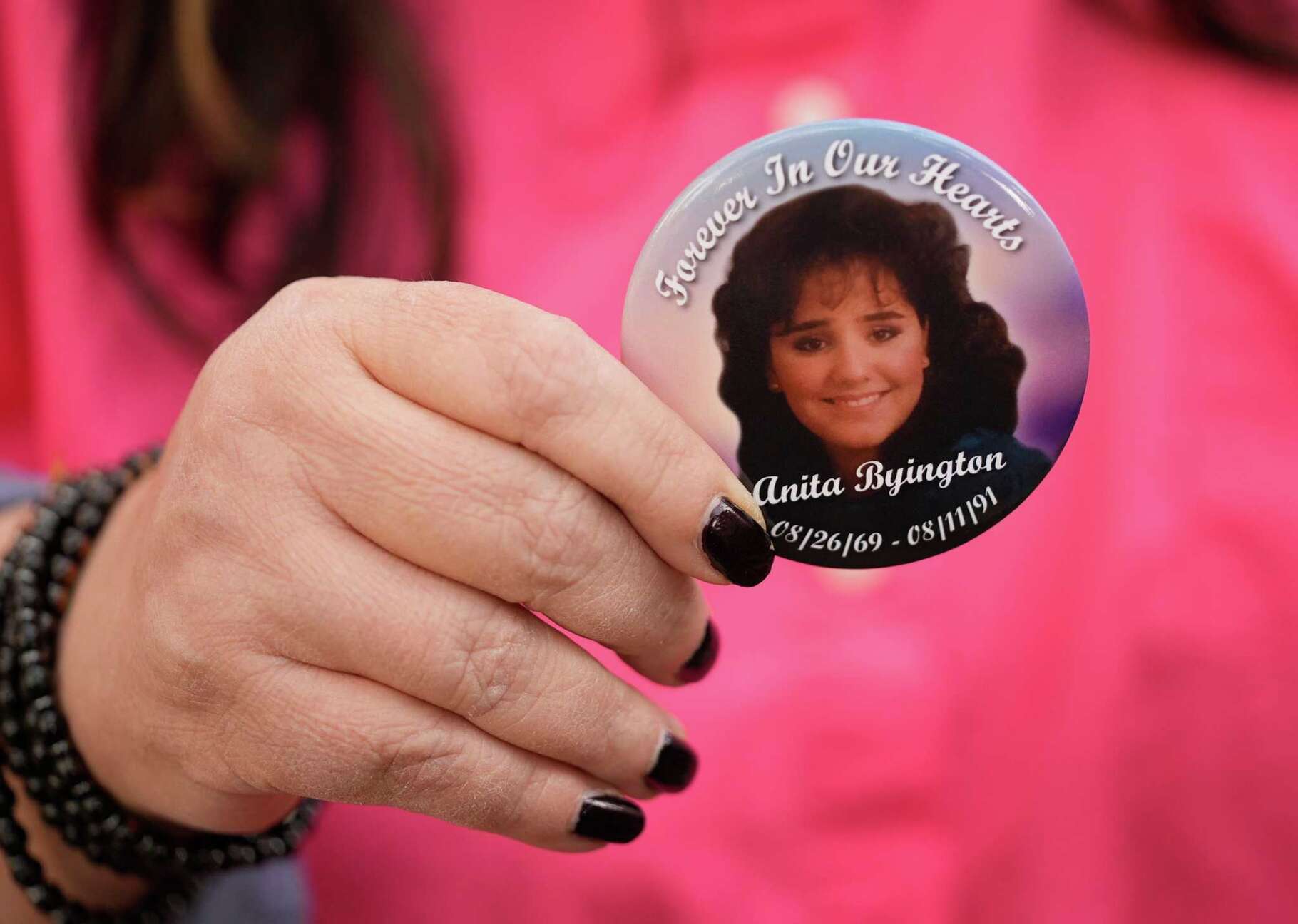 Kristina Byington displays a pin honoring her cousin Anita Byington. Kristina Byington accuses the district attorney's office of failing to properly investigate Allen Andre Causey's claim of innocence in Anita's slaying.