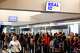 Travelers are seen May 7 at an SFO security checkpoint. The FAA said Wednesday that it would order airlines to reduce scheduled air traffic at 40 major airports starting Friday — including San Francisco and Oakland.